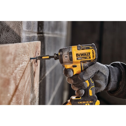 XR 3-speed impact driver fastening screw through wood on concrete.