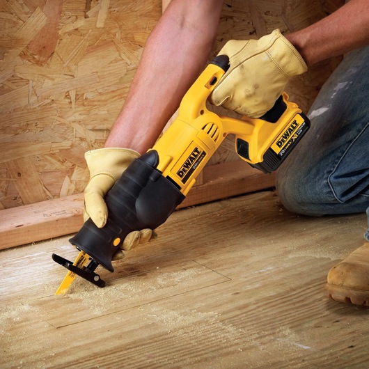 Cordless Reciprocating Saw being used to cut through wooden floor.