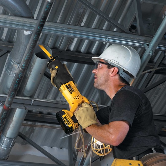 Cordless Reciprocating Saw being used by worker to cut ceiling pipe at job site